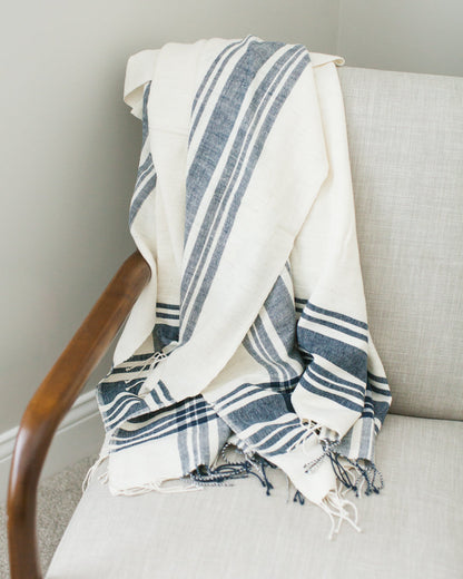 The Cabin Hatch throw folded over the arm of a linen chair