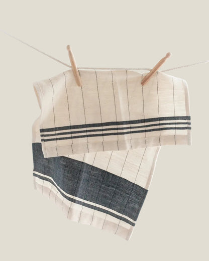 Chelsea striped tea towels with navy bands hanging from a line with wooden clothespins