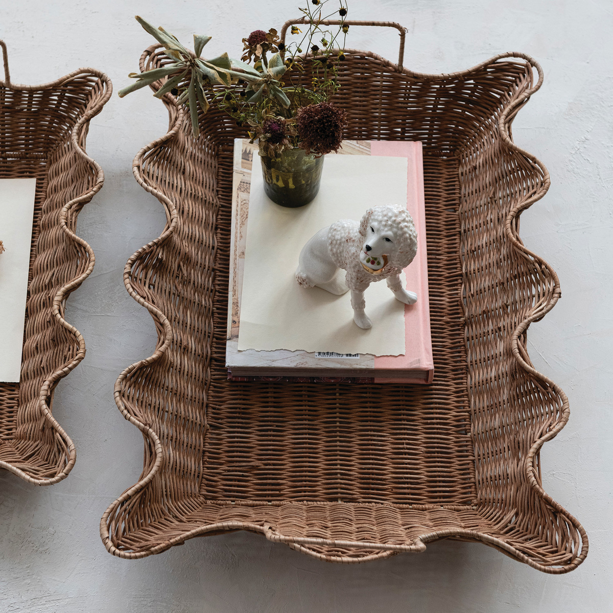 Scalloped rattan tray styled with books, a vase and a small figurine