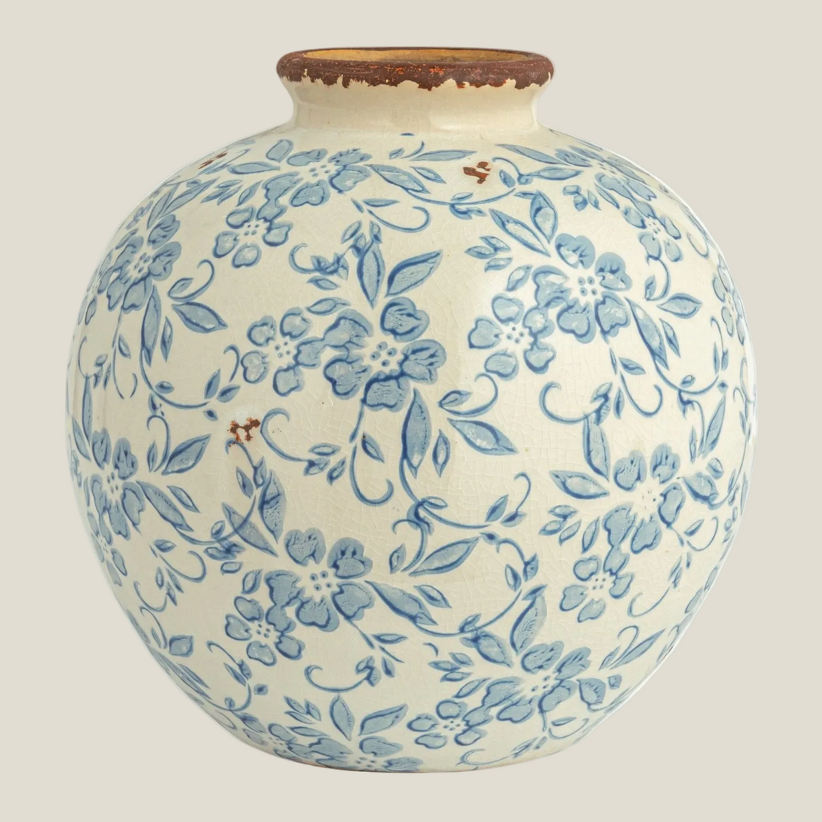 Round terra-cotta vase in cream with a blue transferware-style floral pattern and rustic brown rim, front view