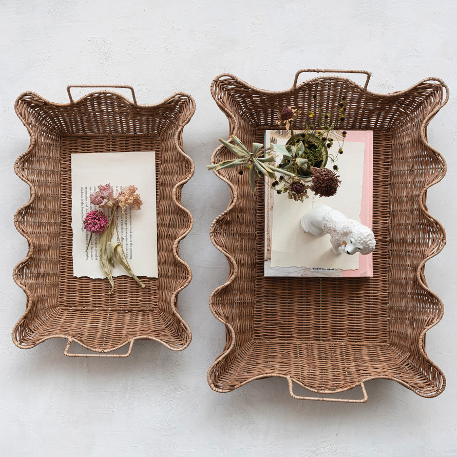 Two scalloped rattan trays styled with books and dried flowers
