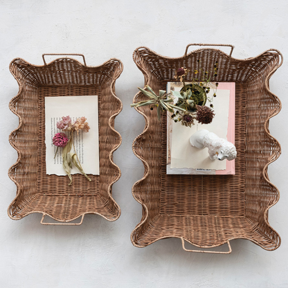 Two scalloped rattan trays styled with books and dried flowers