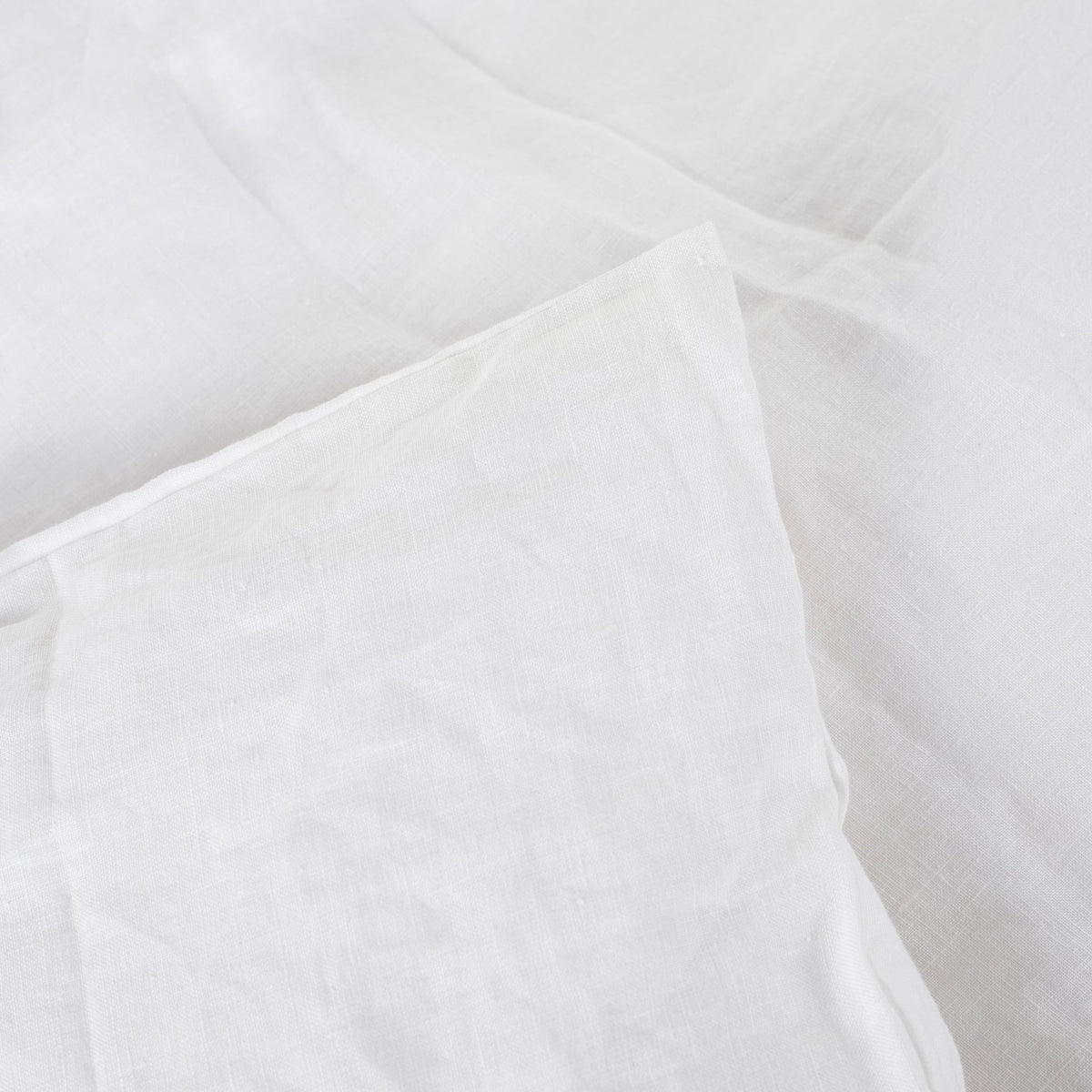 Close-up of the soft white natural linen duvet cover fabric and its relaxed texture