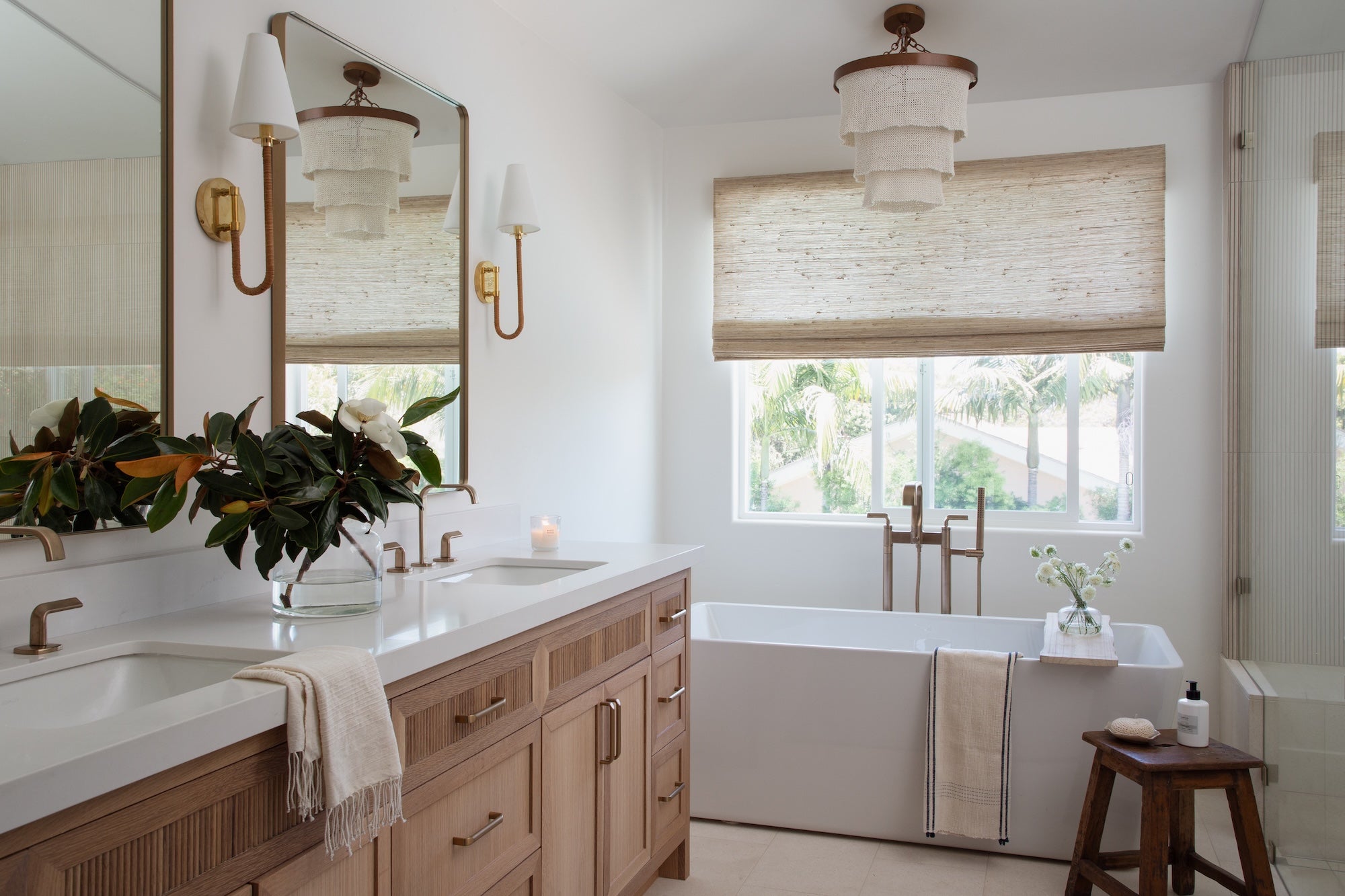 Bathroom with double sink vanity, bathtub, and large window.