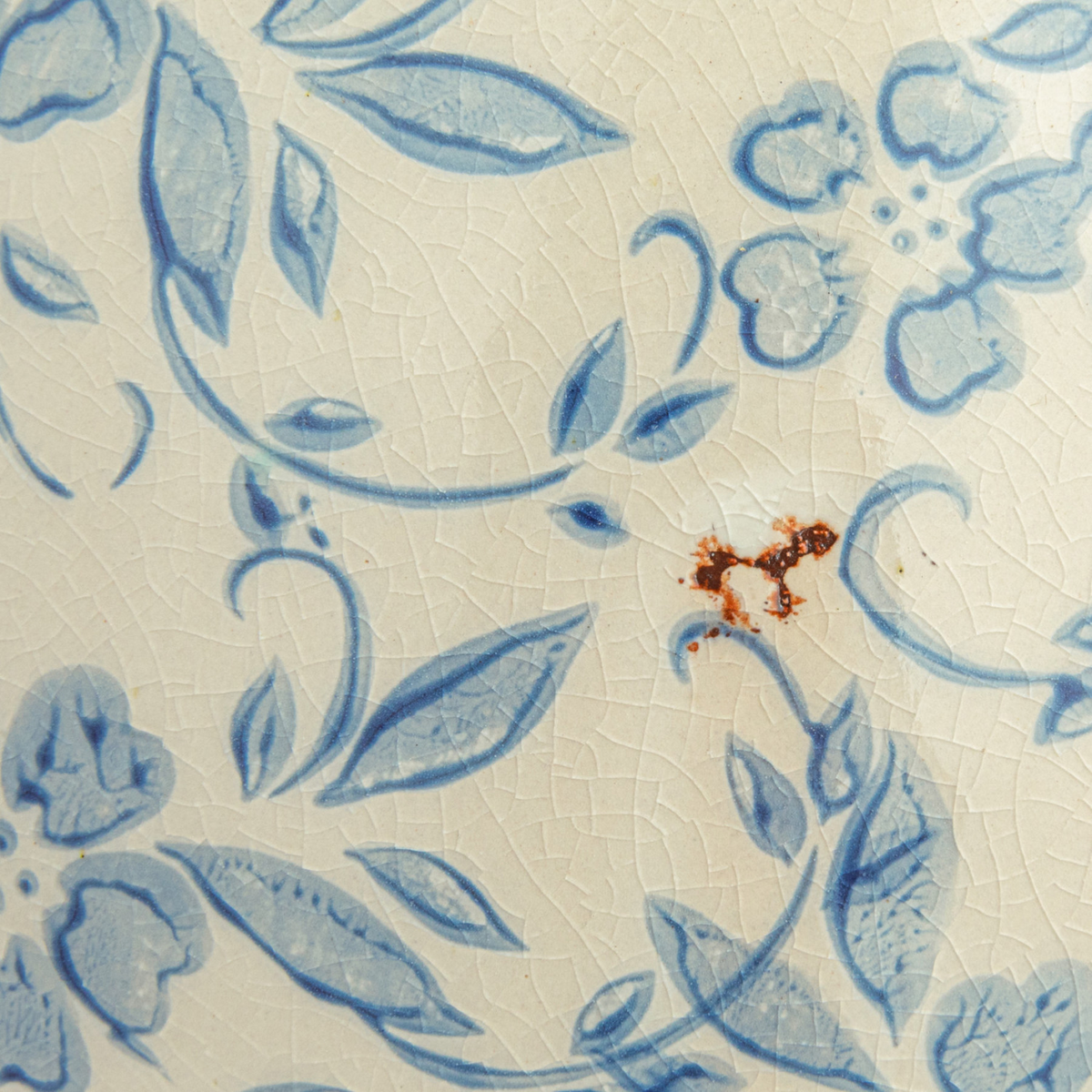 Close-up of the crackled cream glaze and blue floral transferware pattern on the terra-cotta vase