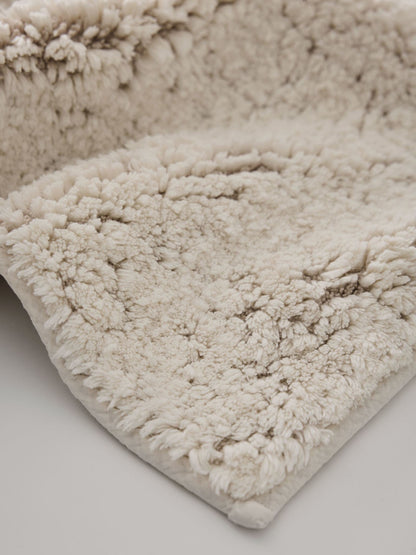 Close-up of the Elsa bath mat's dense, soft off-white cotton and linen pile