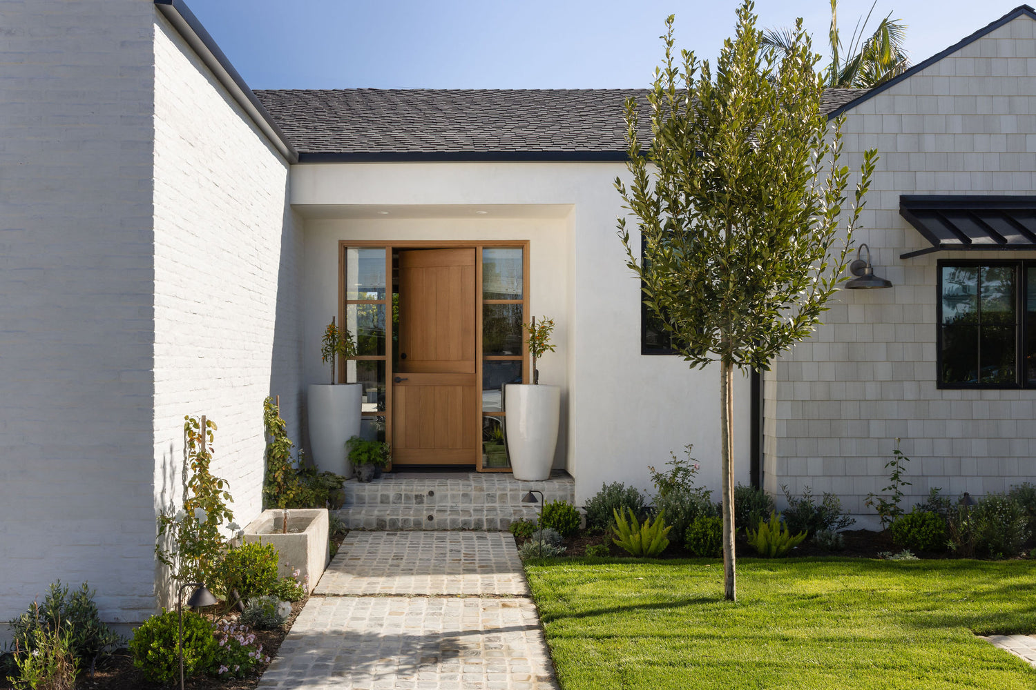Entry with white oak Dutch door, white brick, and cedar shingle siding at the Dover Shores whole-home renovation, Newport Beach, California — Joey Snow Design Co.