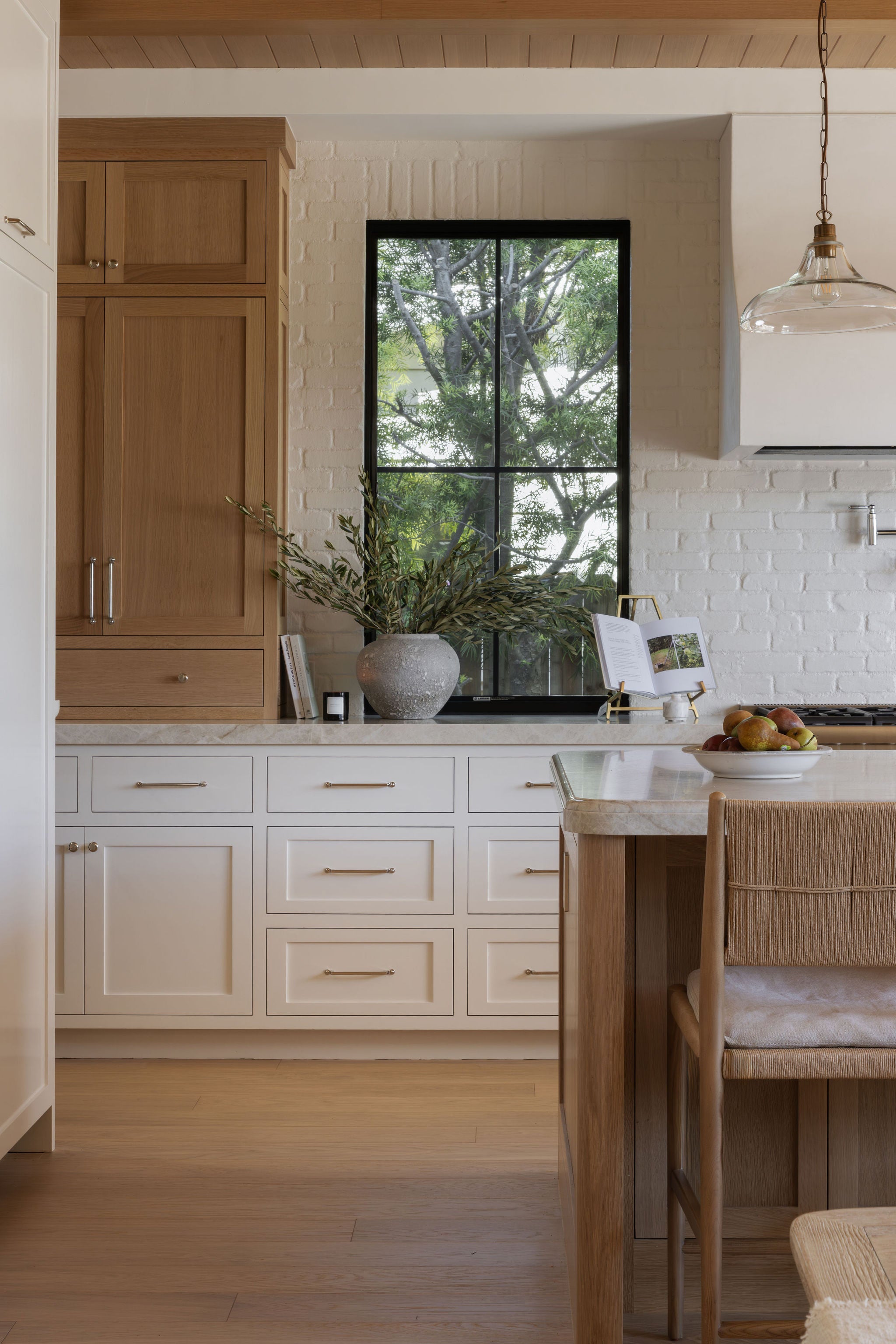 White oak kitchen cabinetry, black casement window, and wood plank ceiling in the Dover Shores whole-home renovation, Newport Beach, California — Joey Snow Design Co.