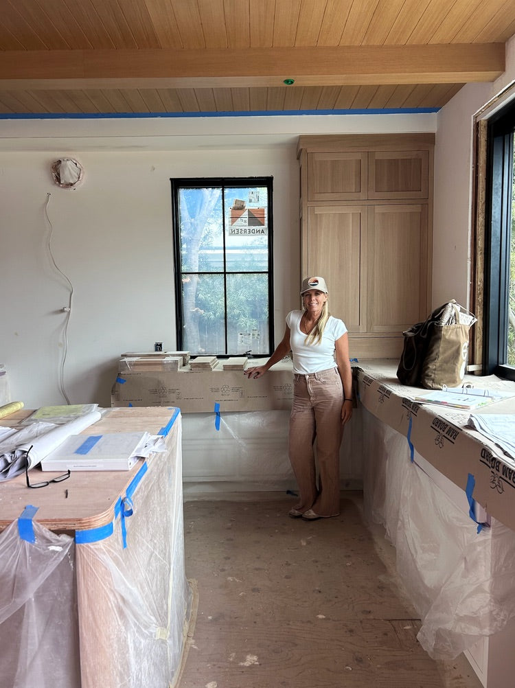 Joey Snow on-site at the Dover Shores Project kitchen showing rift cut white oak ceiling, Andersen black casement window, and custom white oak built-ins